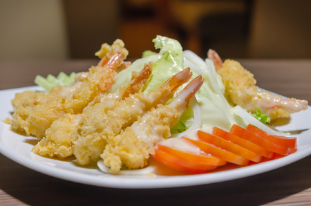 close up deep fried shrimp and  fresh vegetable salad on  white plate の写真素材