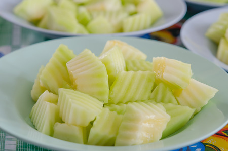 close up several cut green melon on the shallow dish