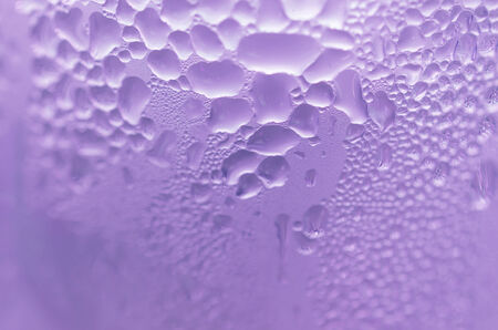 Water droplets on the glass with a colored background. Drops of water.の写真素材