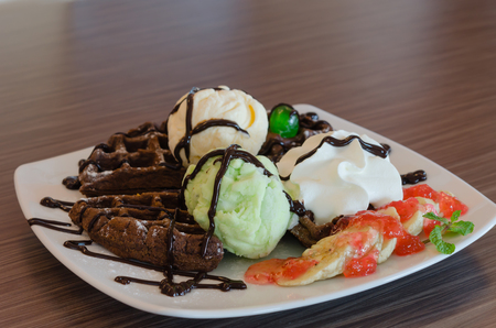 ice cream , chocolate waffles with chocolate sauce and whipping creamの写真素材