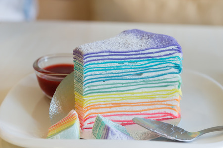 Rainbow crepe cake served with strawberry sauceの写真素材