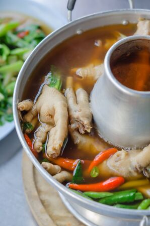 sour and spicy chicken feet soup in hot bowlの写真素材