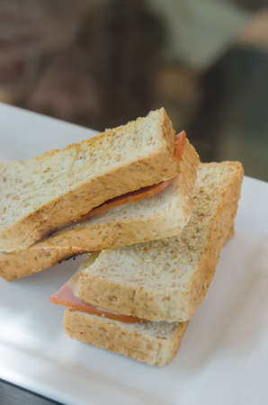 close up toasted sandwich with ham and cheese on dish