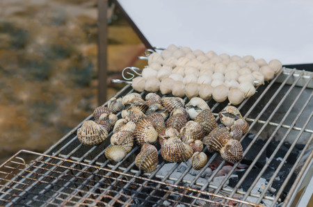 close up seafood bbq ,  cockles on flaming grillの写真素材