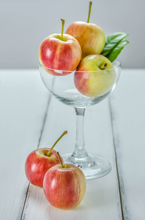fresh red and yellow apple with glass on wooden backgroundの写真素材