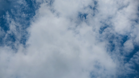 White fluffy clouds on a blue sky backgroundの写真素材