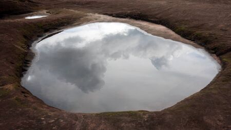 Reflection of rain clouds in the puddleの写真素材