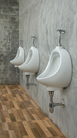 three white urinals men public toilet in restroom outdoorsの写真素材