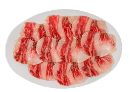 Top view of some raw beef fillets on a plate with  white backgroundの写真素材