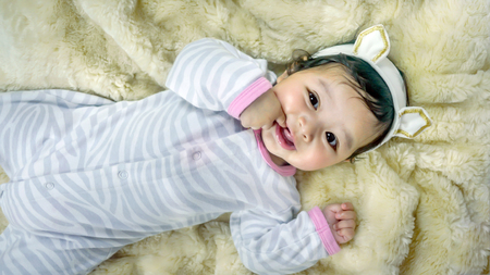 Asian cute baby girl lying on the bedの写真素材