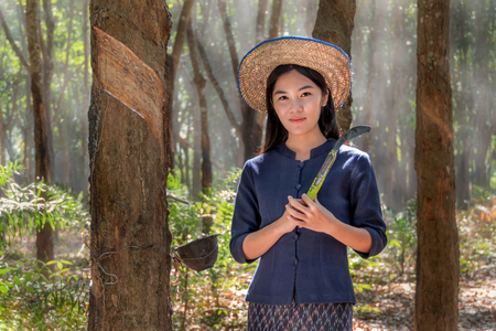 Beatiful asian woman smile in rubber plantation , Thailandの写真素材