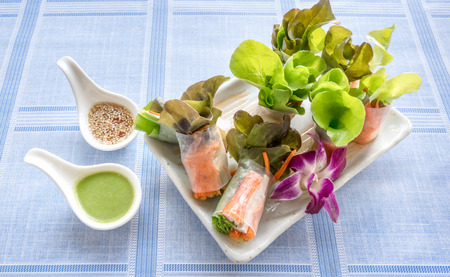 Fresh vegetable salad roll in noodle tube with crab stick on dishの写真素材