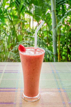 Healthy smoothie in a glass with tomato on a nature backgroundの写真素材
