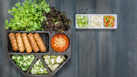 top view of roasted pork served with spicy sauce and vegetable (Nam Neung) on wooden backgroundの写真素材