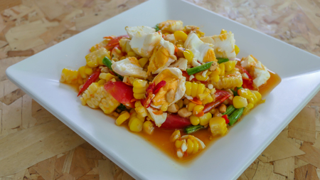 spicy sweet corn salad with salted egg on white dishの写真素材