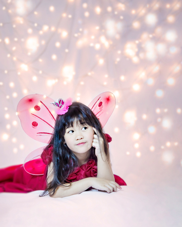 Portrait of asian little cute girl with the light of the bokeh on background, fairy tale conceptの写真素材