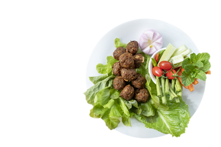 Deep fried spicy minced pork served with fresh vegetables on white plateの写真素材