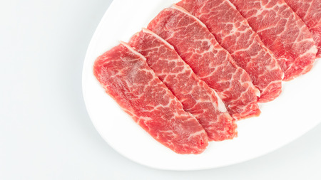 Top view of some raw beef on a plate over white backgroundの写真素材
