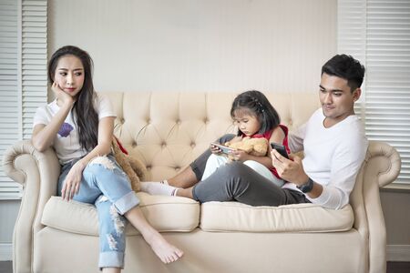 Upset mother bored her child and his father for using cell phone, internet addictionの写真素材