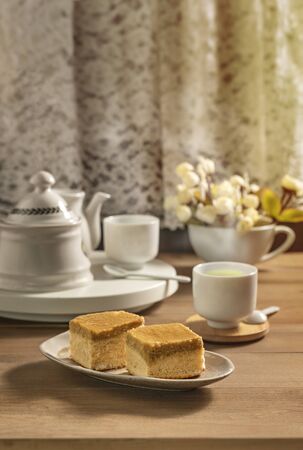 hot tea and sweet cake over wooden tableの写真素材