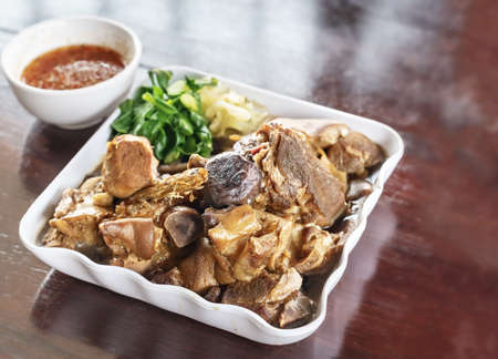 stewed pork knuckle with herb and pickled vegetables on plateの写真素材