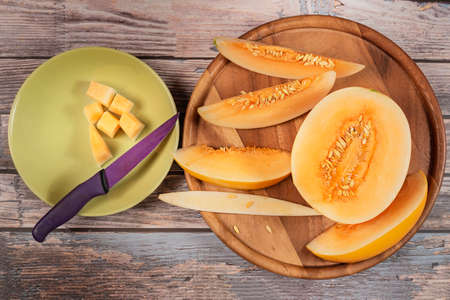 top view fresh ripe melon with slice on plateの写真素材