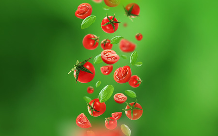 Cherry tomatoes and leaves falling from the airの写真素材