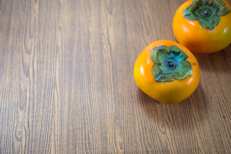 Persimmon fruits on the wooden tableの写真素材