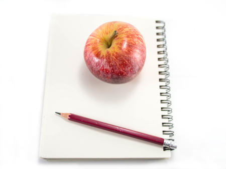 Isolated red apple with the blank notebook and pencilの写真素材