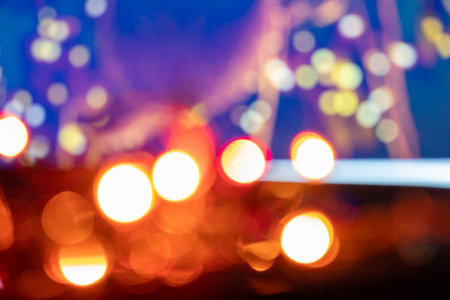 Abstract blue bokeh texture on black background with defocused colored lights making the bokeh effectの写真素材