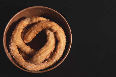 Spanish churros in a bowl on black background. Typical foods of Spainの写真素材