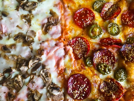 Pizza with peperoni, cheese, ham and mushrooms close up photo