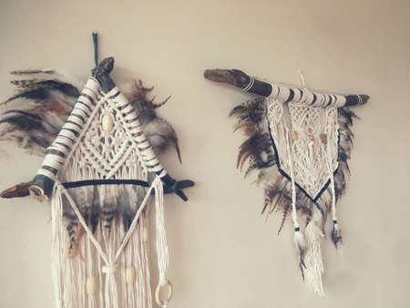 Handmade wall hanging white color with feathers. Home decor photo