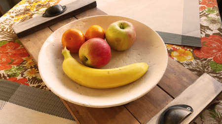 Fruits in a plate on a wooden table in the kitchen.の写真素材