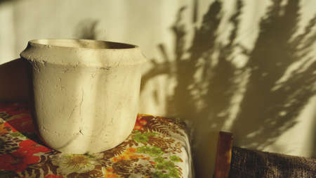 Home decor with a white earthenware vase on the floral  tablecloth. Living room decoration. style, design . High quality photoの写真素材