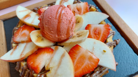 Strawberry, apple, and chocolate ice cream on waffles.の写真素材
