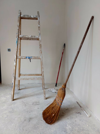 Old wooden stepladder and broom in a new house under constructionの写真素材