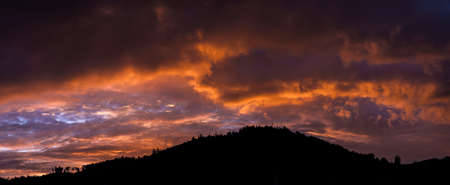 Fantastic cloud game - sunrise behind a hill
