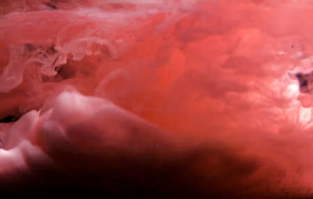 Pink acrylic paint creates abstract shapes in waterの写真素材