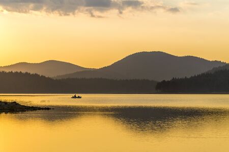 The sunset, the boat, the fishermanの写真素材