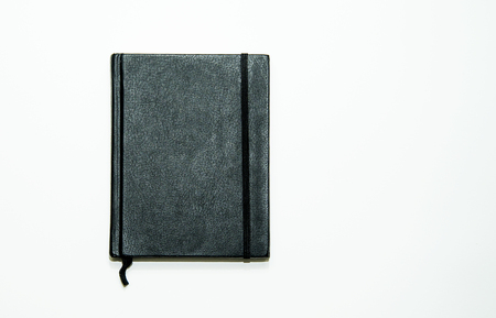 Black leather notebook isolated on white backgroundの写真素材
