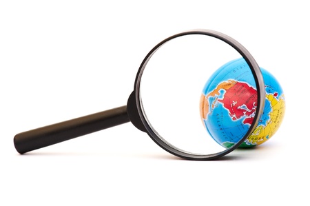 Globe under magnifying glass on isolated white background の写真素材