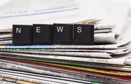  The image shows a stack of newspaper with set of letters  news 