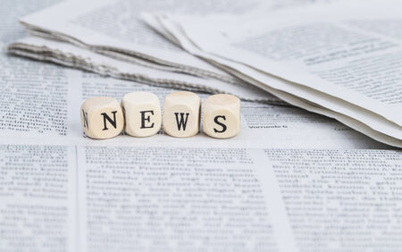 News formed by wooden letters, on top of newspapersの写真素材