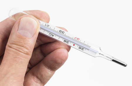 Hand is holding a fever thermometer isolated on white backgroundの写真素材