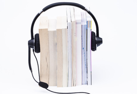 A stack of books and a headphone on white backgroundの写真素材
