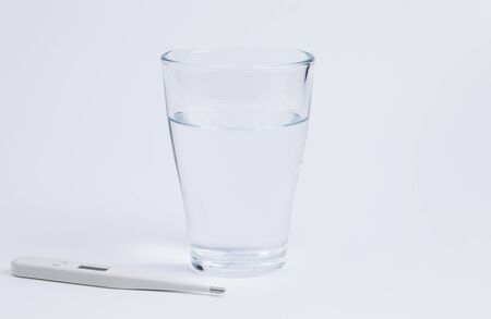 Image shows a glas of water with a clinical thermometerの写真素材