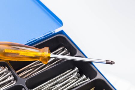 Box with various screws with a screw driver
