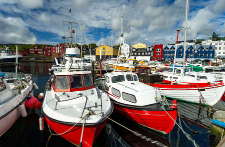 The photo shows different ships in a port on the Faroe Islandsの写真素材