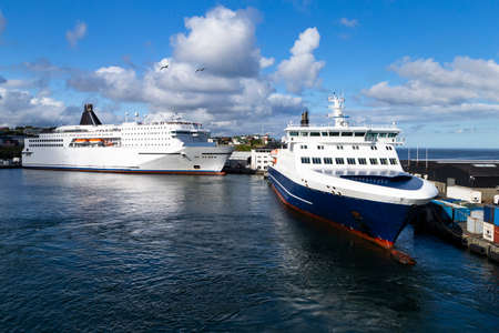 The photo shows two large ferries on the island of Orkney, tied up to a pierの写真素材